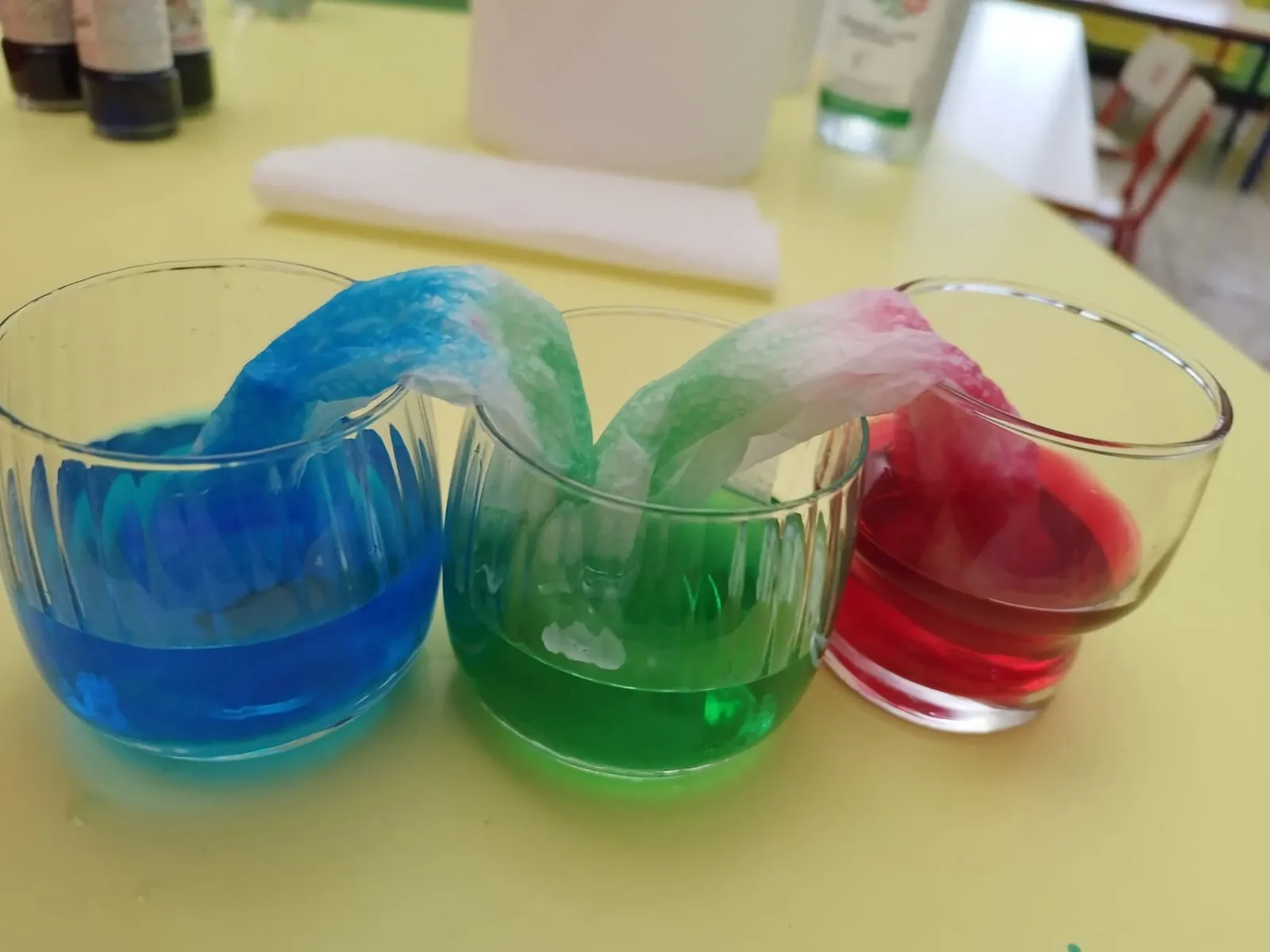 Esperimento con tre bicchieri di acqua colorata e carta assorbente