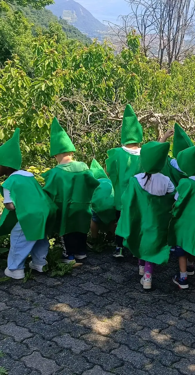 Bambini vestiti da folletti osservano le piante durante la gita