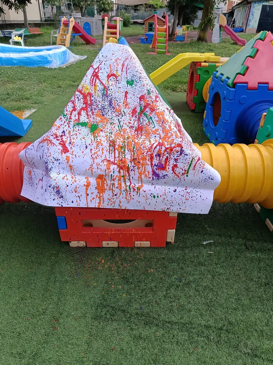 Grande foglio dipinto a schizzi di colore steso sui giochi in giardino