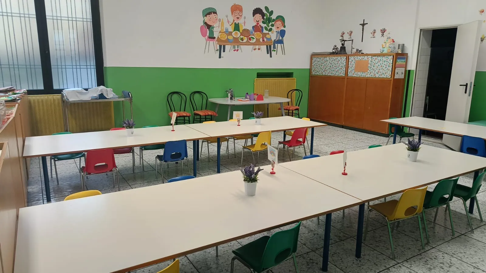 Sala da pranzo della scuola dell'infanzia di Albegno con i tavoli apparecchiati
