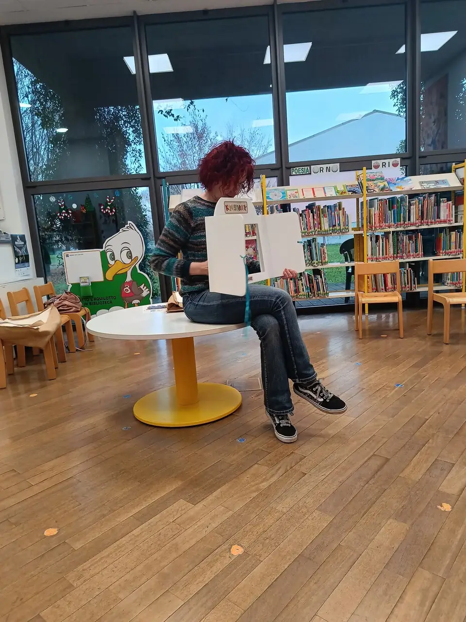 Lettura ad alta voce in biblioteca durante la visita mensile